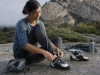 Best Climbing Shoes for Women That Won’t Wreck Your Feet Woman lacing La Sportiva Katana Lace climbing shoes at the base of a granite crag before her first route