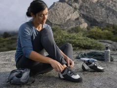 Best Climbing Shoes for Women That Won’t Wreck Your Feet Woman lacing La Sportiva Katana Lace climbing shoes at the base of a granite crag before her first route