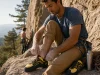 Best La Sportiva Climbing Shoes by Discipline Climber lacing a La Sportiva Katana Lace shoe on warm granite at a crag before a route