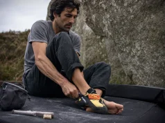 9 Scarpa Climbing Shoes Compared in One Table Climber pulling on Scarpa Drago climbing shoes at the base of a granite boulder