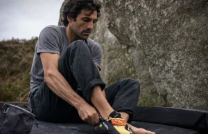 9 Scarpa Climbing Shoes Compared in One Table Climber pulling on Scarpa Drago climbing shoes at the base of a granite boulder
