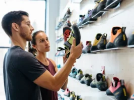 Diverse climbers choosing the right fit from a selection of La Sportiva climbing shoes in a gear shop size guide context.