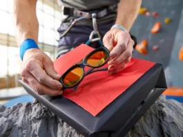 Climber happily unwrapping unique rock climbing gifts they actually want, like belay glasses or a chalk bag.