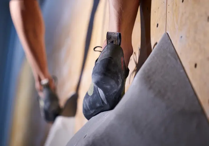 Why perfect fit matters: Close-up of a climbing shoe fitting perfectly on a small foothold, showing the performance connection.