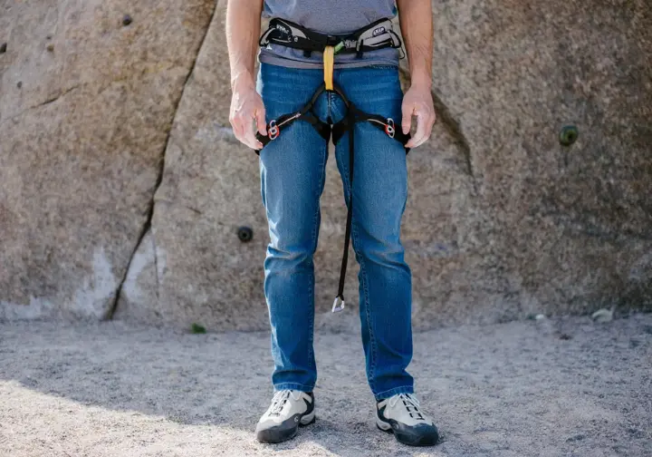 Climber incorrectly wearing harness with waistbelt too low, highlighting a common and dangerous harness mistake.