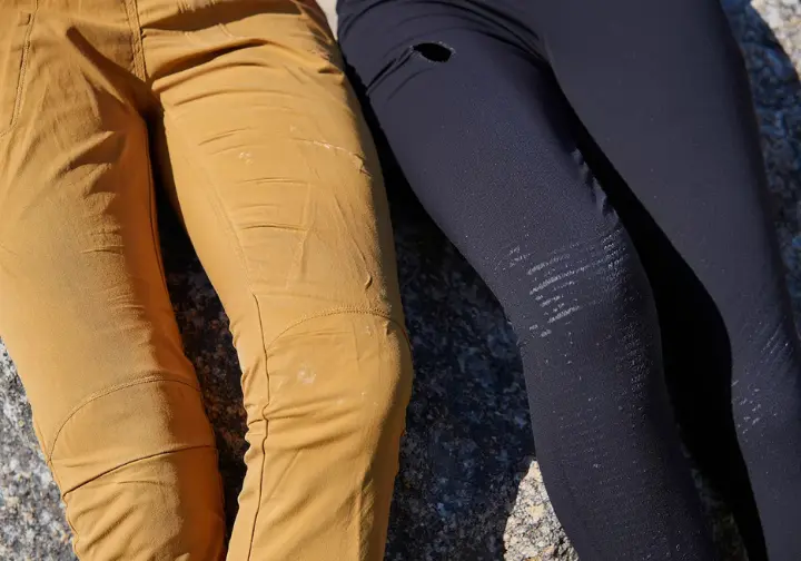 Climbing pants versus leggings durability debate illustrated by durable pants next to snagged leggings on rock.