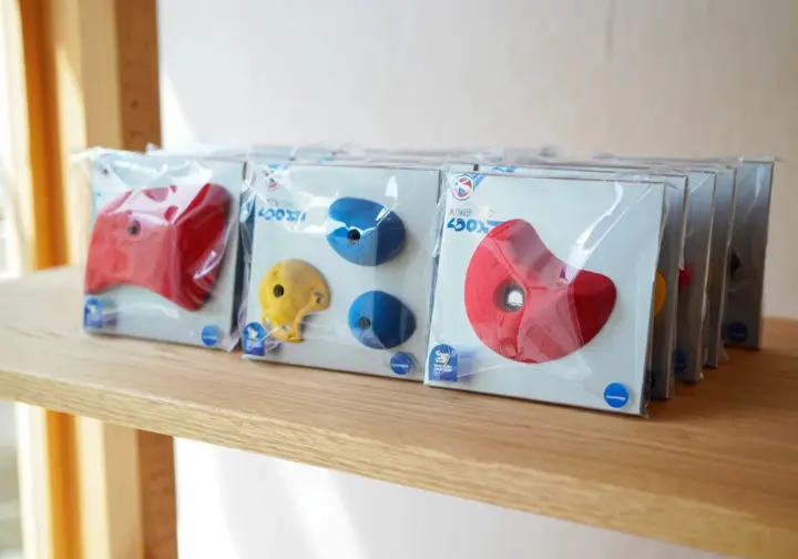 Display of top climbing hold sets and brands packaged for home wall purchase.