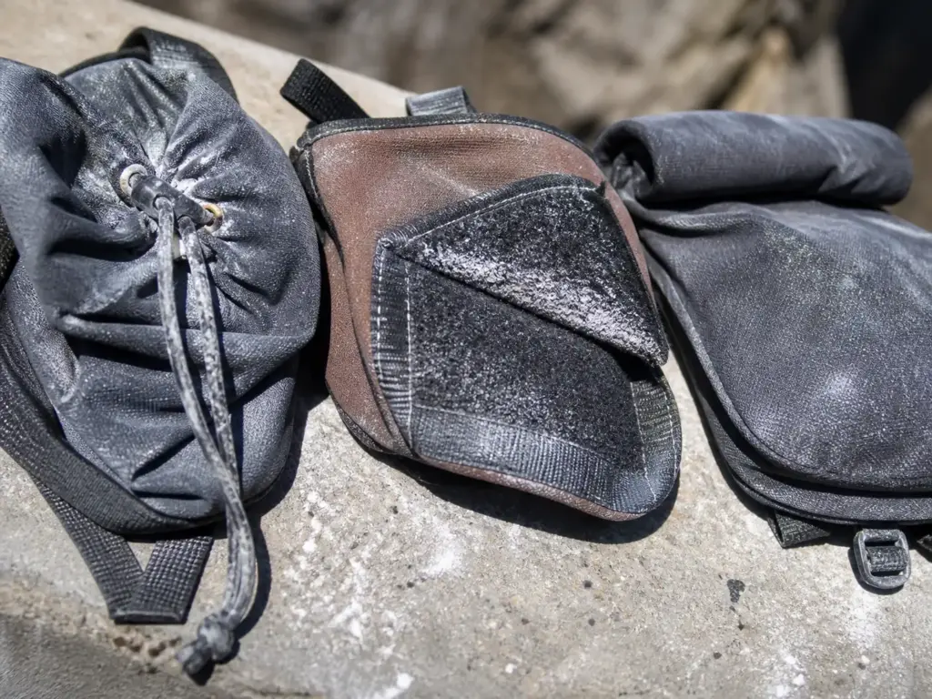 Close-up of a chalk bag drawstring closure pulled tight with chalk residue caked around the cord and grommets