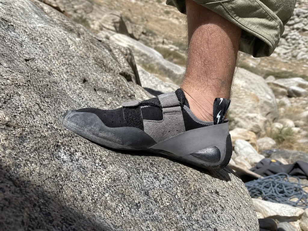 Flat neutral Evolv Defy climbing shoe smearing on a low-angle granite slab foothold