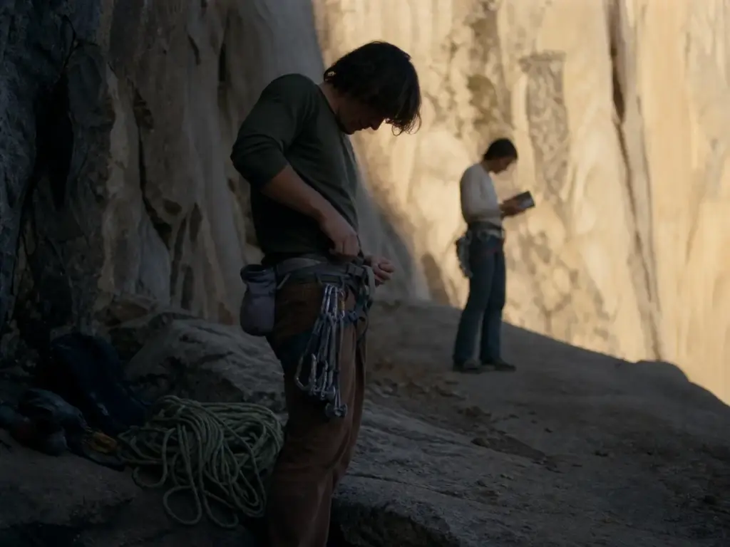 Climber racking up at the base of a multi-pitch route with a compact chalk bag belted at the waist