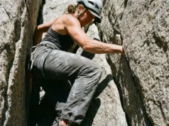 Best Ladies Climbing Pants: Sustainable & Durable Picks A female rock climber stemming a granite crack wearing durable technical climbing pants.