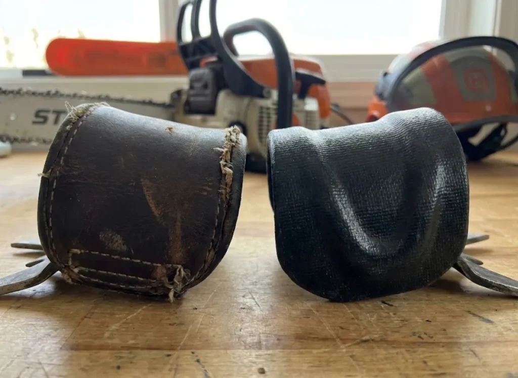 A close-up comparison showing a soft leather climbing pad next to a modern rigid fiberglass cuff on a workbench.