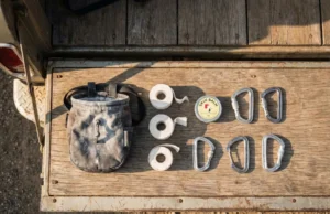 Rock Climber Gift Ideas: Fail-Safe Picks (Ranked) A curated collection of essential rock climbing gear including chalk, tape, and carabiners arranged neatly on a wooden surface.