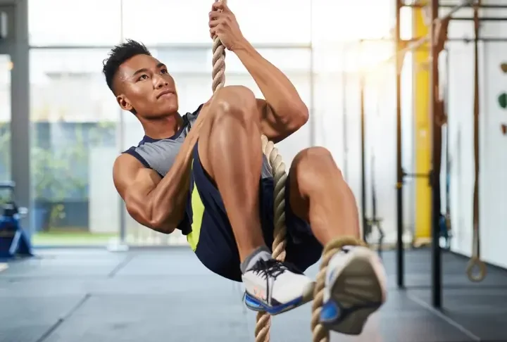 Guide on how to climb ropes using your legs: Climber demonstrating efficient technique with foot lock.