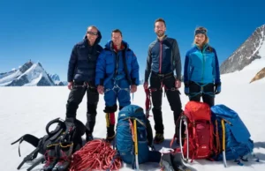 Building Your Mountaineering Gear System: A Full Guide A group of mountaineers with their full set of interconnected climbing gear laid out on snow, ready for a mountain ascent, under clear skies.