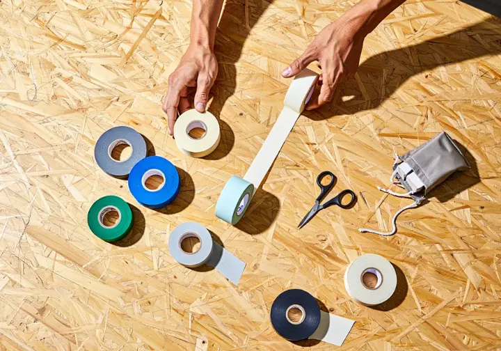 An assortment of various climbing tapes neatly arranged, illustrating a comprehensive guide for climbers choosing the right tape when learning how to tape fingers.