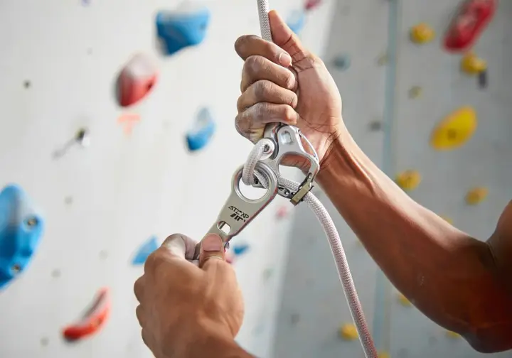 Close-up of a belayer's hands demonstrating correct brake hand technique to avoid common belaying mistakes, vital for how to belay safely.