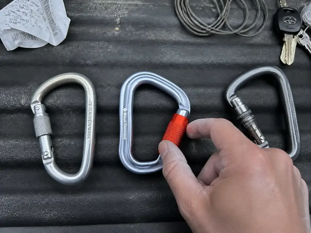 Screwgate and twist-lock carabiners laid out side by side comparing locking mechanisms