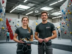 From Renter to Owner: Your First Indoor Gear Guide Two climbers, a man and a woman, proudly displaying their new indoor climbing gear in a brightly lit gym, signifying the transition from renter to owner of climbing equipment.