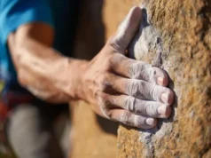The Science of Grip: An Ultimate Climbing Chalk Guide A close-up of a climber's chalked hand gripping a rock hold, illustrating the science of grip for the ultimate climbing chalk guide.