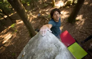 Unlock Boat Rock: SCC, Granite & Bouldering Deep Dive Climber at the summit of a distinctive granite boulder at Boat Rock bouldering area, symbolizing a deep dive into SCC conservation, unique granite features, and bouldering challenges.