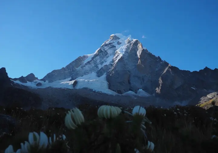 Majestic sunlit Peruvian Andean peak viewed from a low angle, showcasing the allure of Andean mountaineering in Peru with its stunning natural beauty.