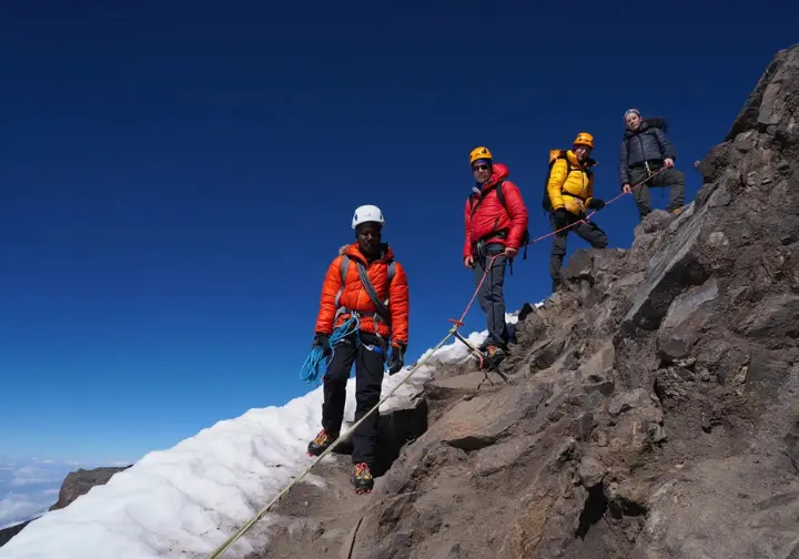 Diverse group of climbers during the challenging ascent phase on a snowy trail of Mount Kilimanjaro, illustrating the mountain climbing experience.