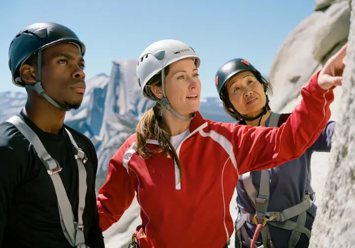 Professional mountain guide explaining guided options to diverse clients for a yosemite climbing half dome experience