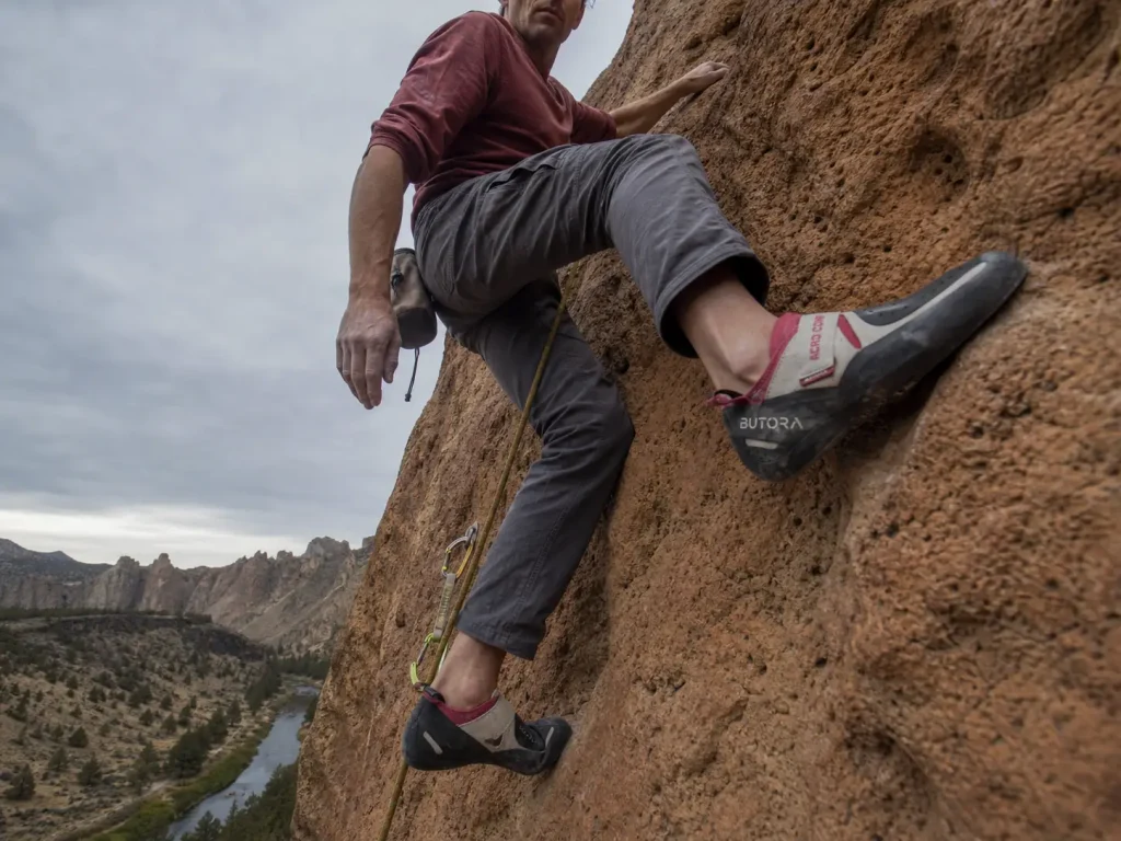 Climber smedging on rounded welded tuff at Smith Rock in Butora Acro Comp climbing shoes