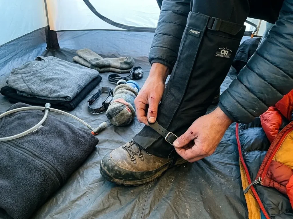 Outdoor Research gaiters and layered gear laid out for climbing Kilimanjaro