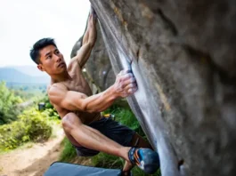 Climber tackling a short, no-rope outdoor boulder problem, showcasing the essence of bouldering and what a boulder problem entails.