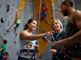 Instructor guiding students on CWI certification choices (AMGA, CWA, PCIA) for climbing wall instructor certification.