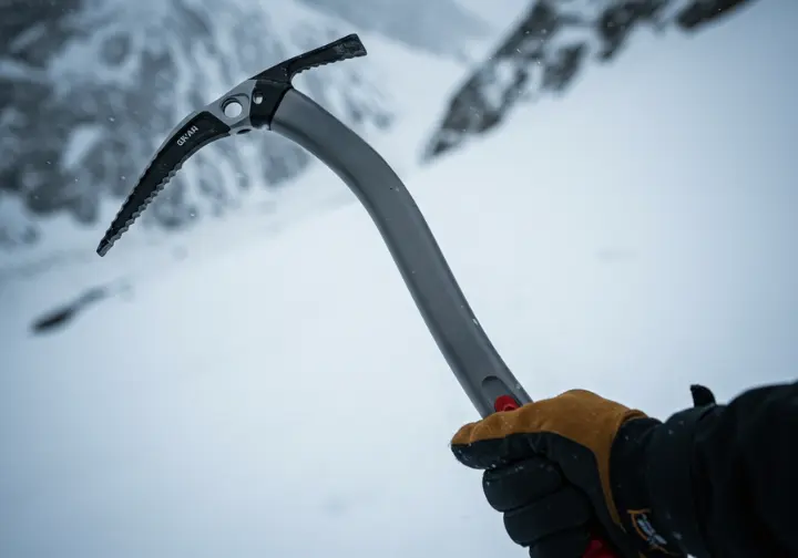 Close-up of an ice axe head and shaft, highlighting its anatomy and design for ice climbing.