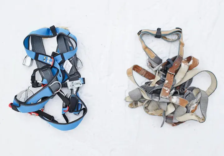 Two climbing harnesses, one new in packaging (shelf life) and one used (service life), illustrating the difference in how long a climbing harness lasts based on its state.