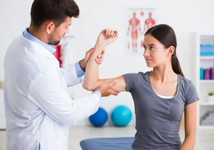 Diagnosing common climber elbow issues: professional performing a test on a climber's elbow due to pain from rock climbing.
