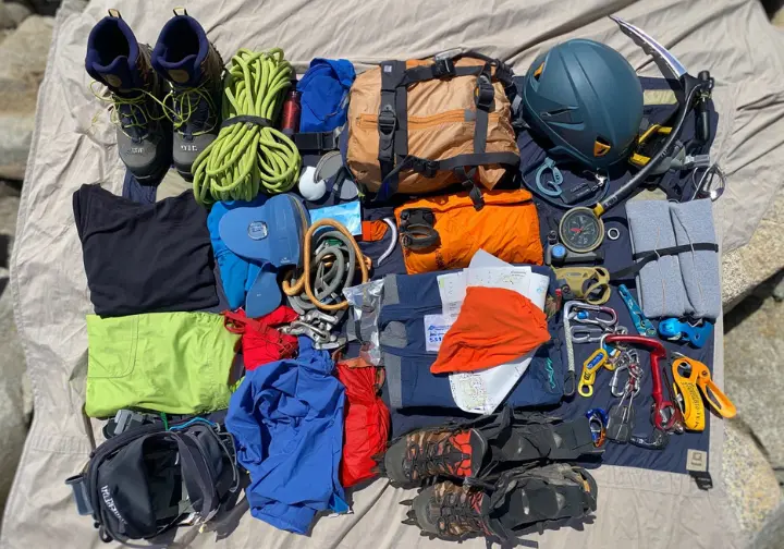 Essential gear packed for success and safety on the Mount Whitney Mountaineer's Route, including ice axe, crampons, and helmet.