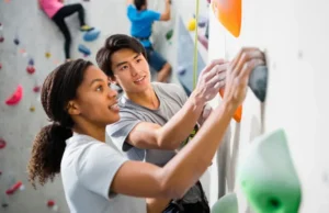 Your First Climb: How to Learn Rock Climbing Safely Learn how to rock climb safely: diverse instructor guiding a beginner on their first climb in a gym.