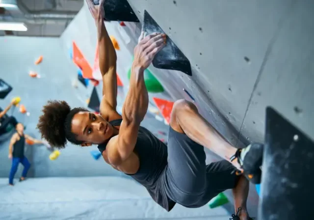 Master core exercises for bouldering: diverse female climber showcasing core strength on a steep overhang to climb stronger.