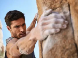 Climber mastering grip strength with chalked hands on a sunlit rock hold, showcasing exercises and plans for climbing.