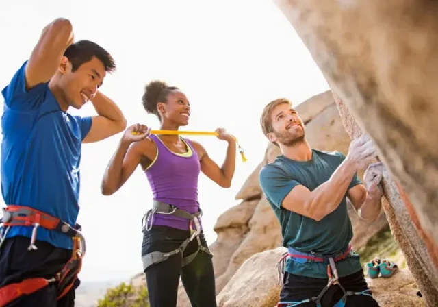 Mastering your rock climbing warm up: diverse climbers performing exercises to prevent injury now.
