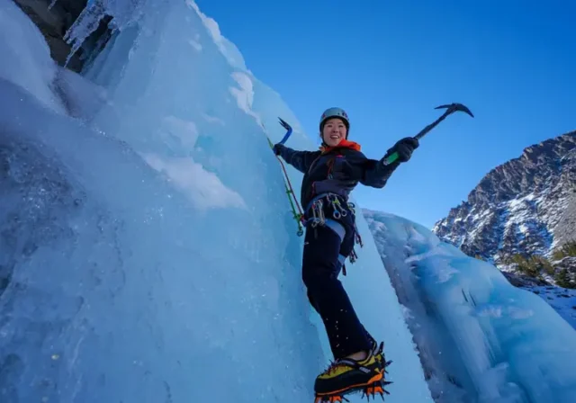 Mastering Lee Vining ice climbing: diverse female climber ascending blue ice routes amidst stunning Eastern Sierra conditions.