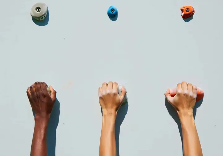 Diverse hands demonstrating various climbing grips (crimp, pinch, open-hand) for mastering grip strength exercises.