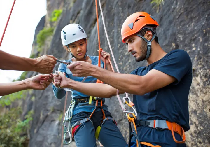 Advanced rock climbing safety: diverse climbers practicing emergency preparedness and self-rescue techniques outdoors.