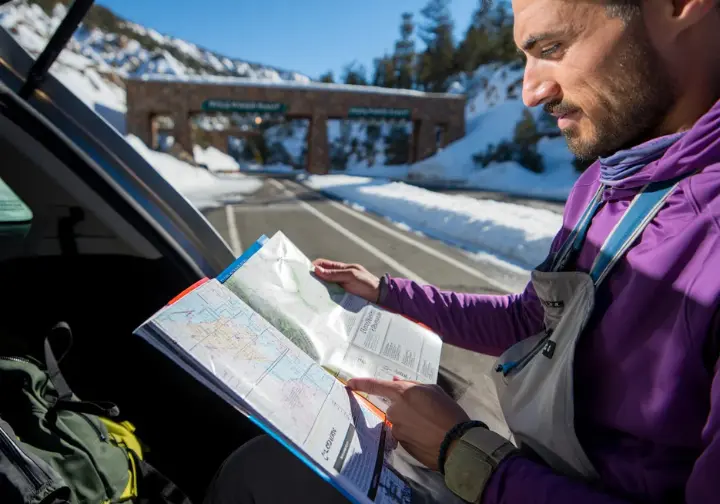 Planning your Lee Vining ice climbing ascent: climber reviewing logistics, guiding, and regulations at the access point.