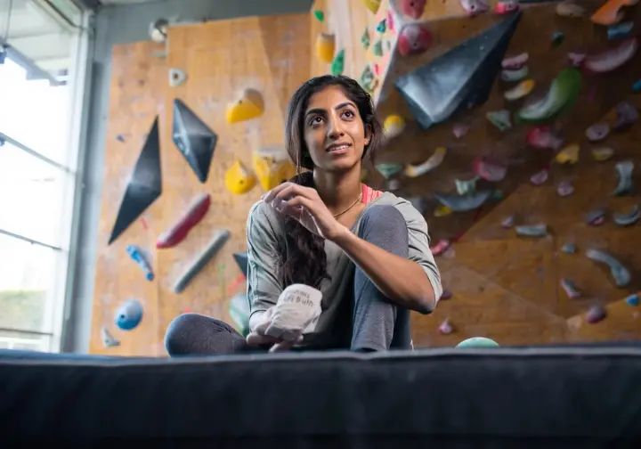 Cultivating a beginner's bouldering mindset: climber thoughtfully analyzing a problem, showcasing problem-solving mind games tips.