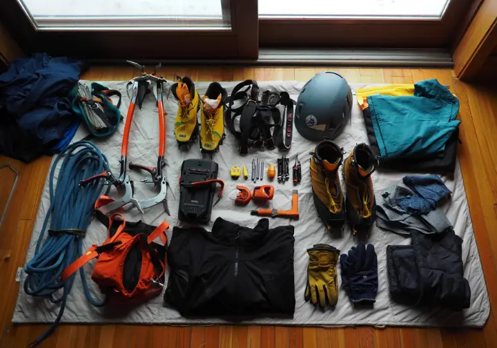 Gearing up for Lake Willoughby ice climbing: a flat lay of essential kit including ice tools, crampons, ropes, and apparel.