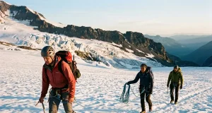 Is Mt Rainier Hard in Summer? Fitness Decides Roped climbing team crossing the Ingraham Glacier on Mt Rainier at sunrise in summer