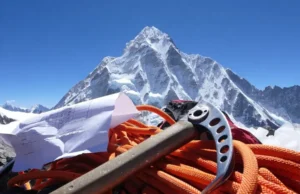 Cost to Climb Everest: Hidden Fees Revealed! Revealing the cost to climb Everest: View of Mount Everest peak with climbing gear and a budget sheet in the foreground highlighting hidden fees.