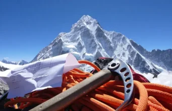 Cost to Climb Everest: Hidden Fees Revealed! Revealing the cost to climb Everest: View of Mount Everest peak with climbing gear and a budget sheet in the foreground highlighting hidden fees.