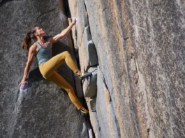 Woman rock climbing outdoors in durable and comfortable women's climbing pants, showcasing style meeting function.